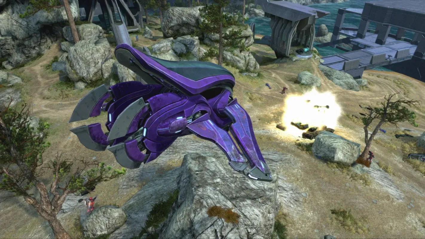 Combate em cenário rochoso de Halo: The Master Chief Collection, com nave Covenant roxa