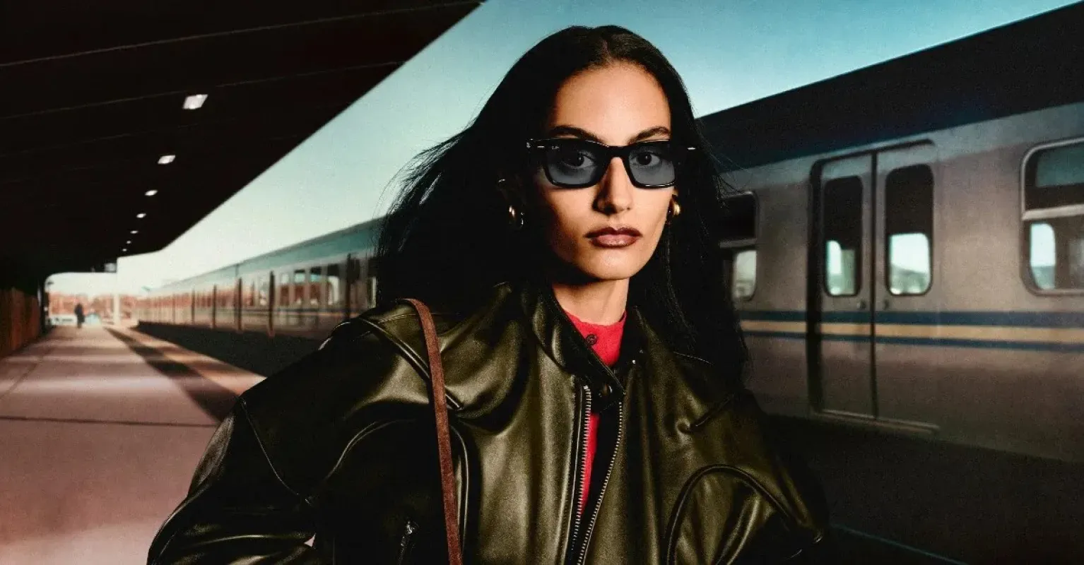 Mulher usando óculos escuros Ray-Ban Meta na plataforma de uma estação de trem