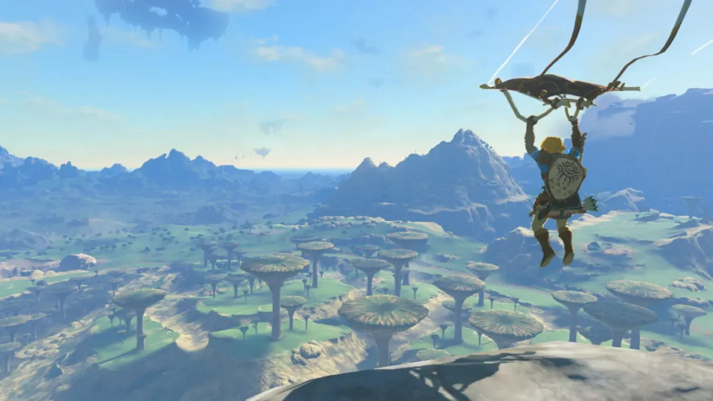 Link planando de parapente sobre montanhas e ilhas flutuantes em The Legend of Zelda: Tears of the Kingdom