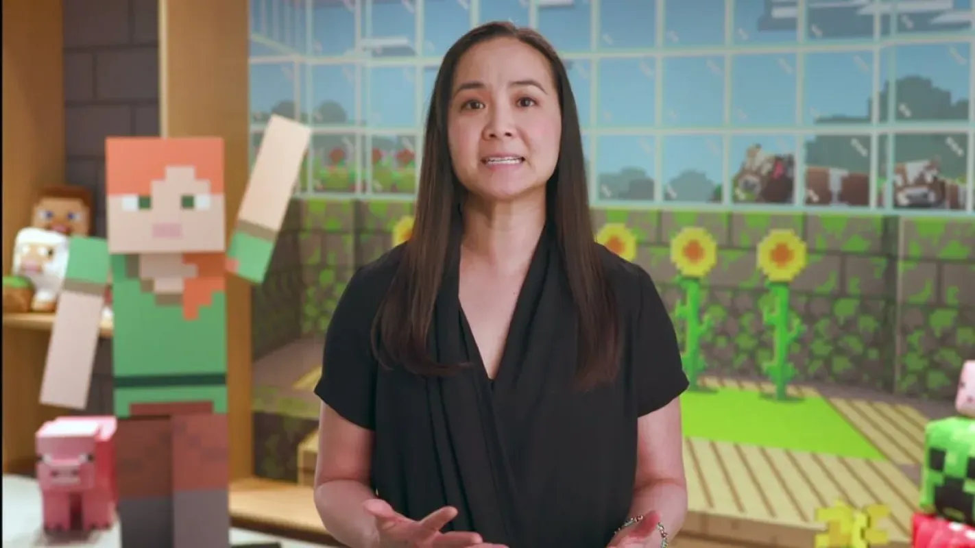 Helen Chiang fala em um cenário decorado com personagens e blocos de Minecraft
