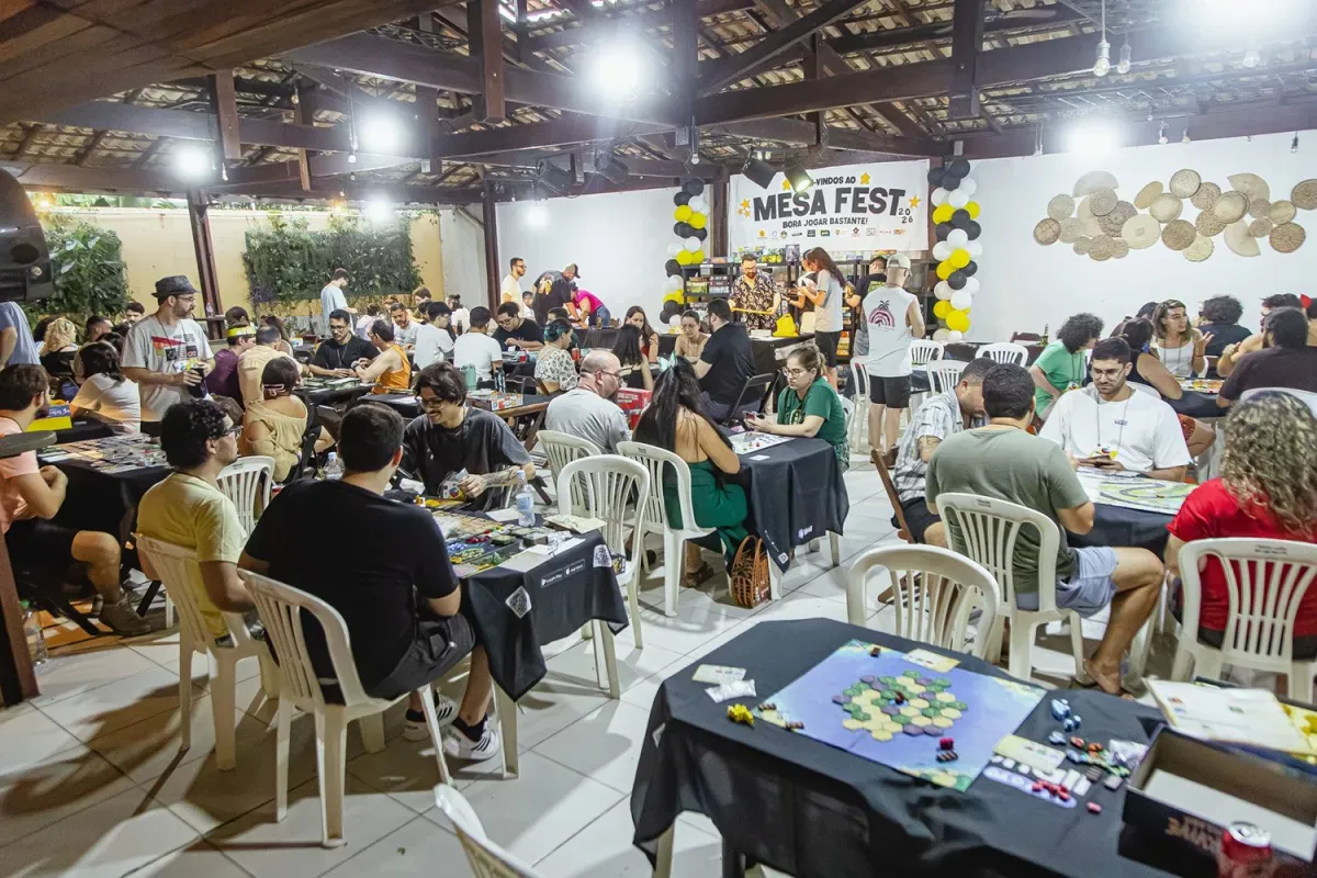 Salão cheio de mesas de jogos de tabuleiro em edição anterior do Mesa Fest